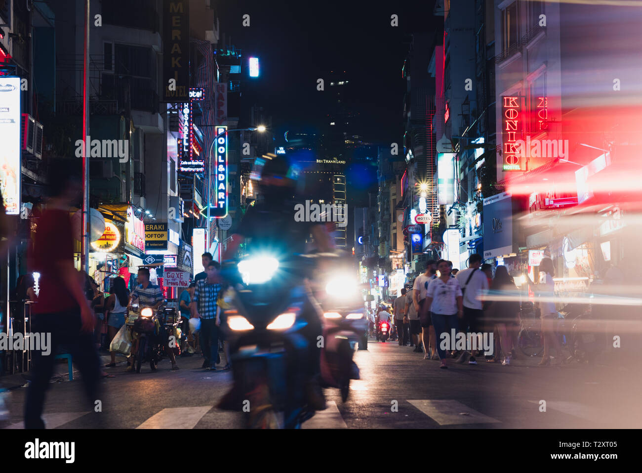 Ho Chi Minh City, Vietnam - April 26, 2018: lights of night Bui Vien Street with its neon sign boards, headlights of motorcycles and a walking crowd. Stock Photo
