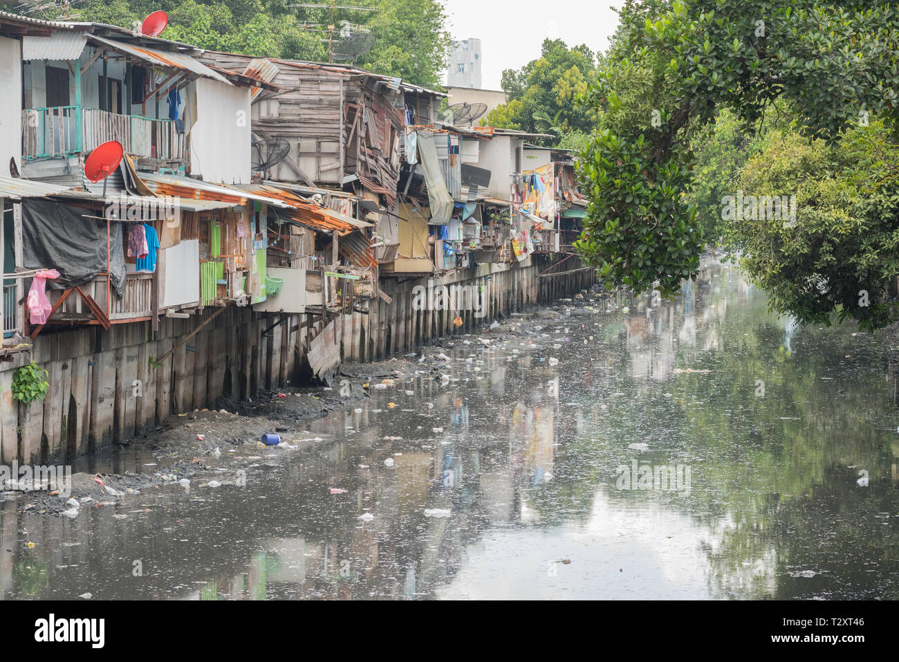 Bangkok, Thailand - September 25, 2018: slums along a smelly canal (Khlong Toei) full of mud and garbage in Khlong Toei District. Stock Photo