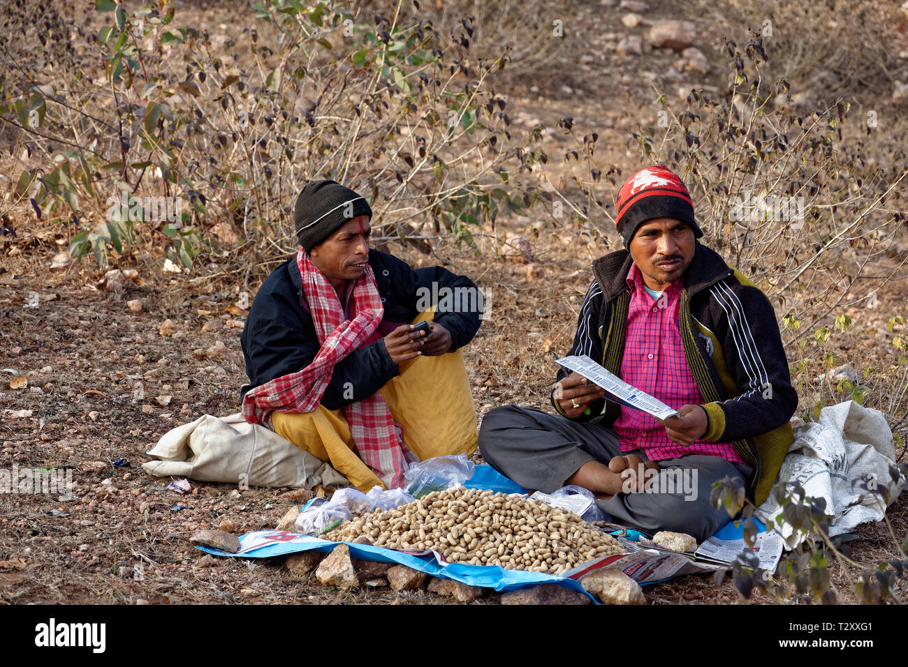 Two men are selling peanuts on a rural fair. Stock Photo