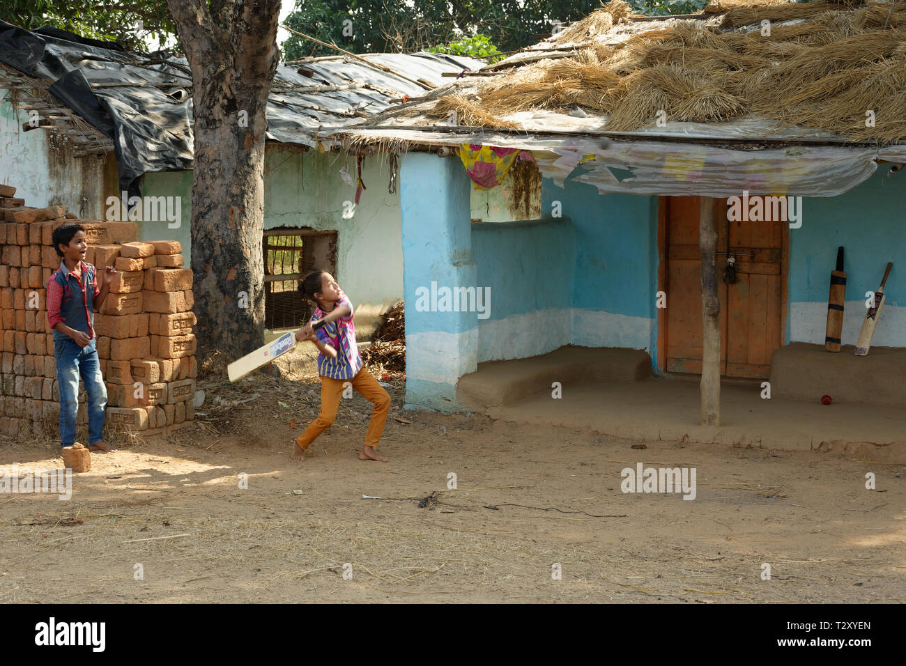 Indian little local boys are playing cricket near hut house Stock Photo