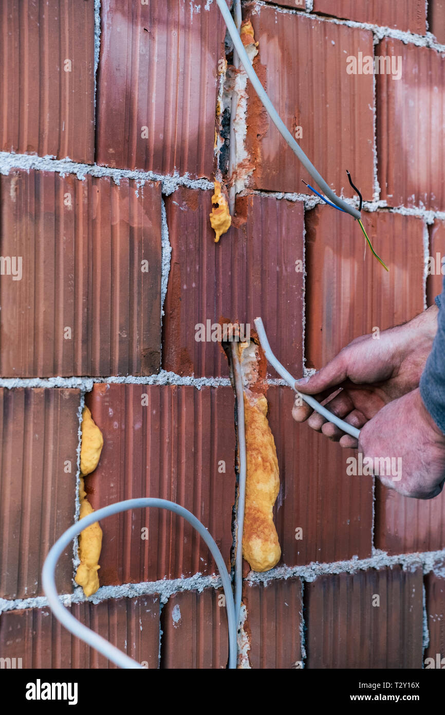 Electrician putting cables trough the house wall Stock Photo Alamy