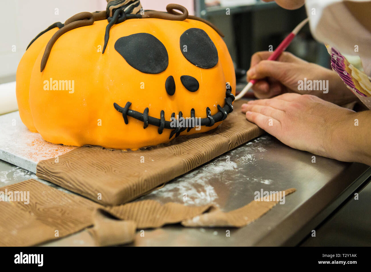 pastry chef is molding a cake with pumpkin shape Stock Photo