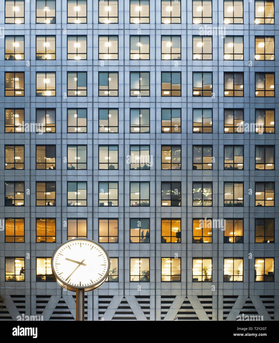 Clock and office windows at dusk Stock Photo
