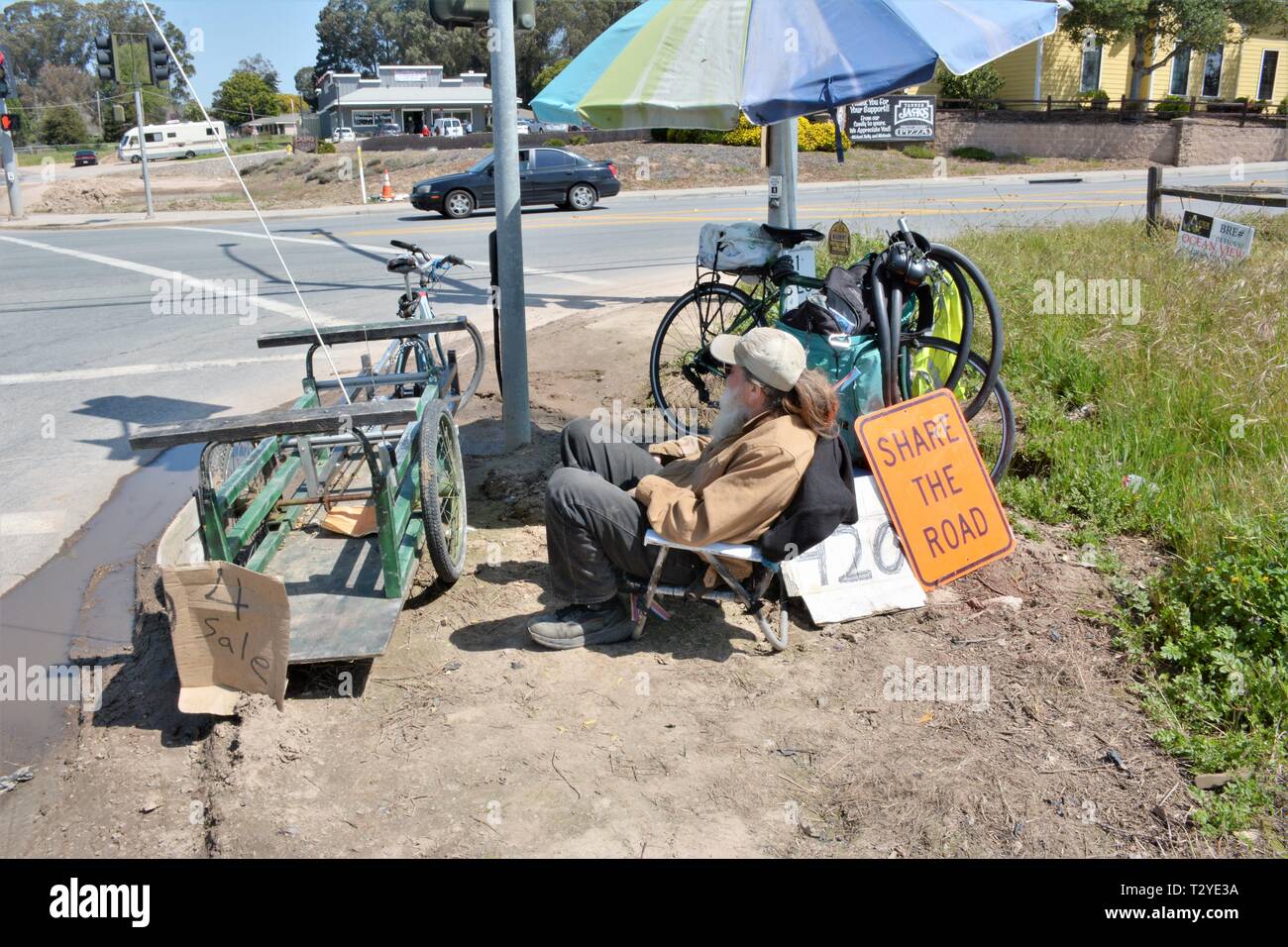 Retired bike repairman who now alters and improves bikes sells them on the corner near the beach on weekends by Pismo Halcyon Stock Photo