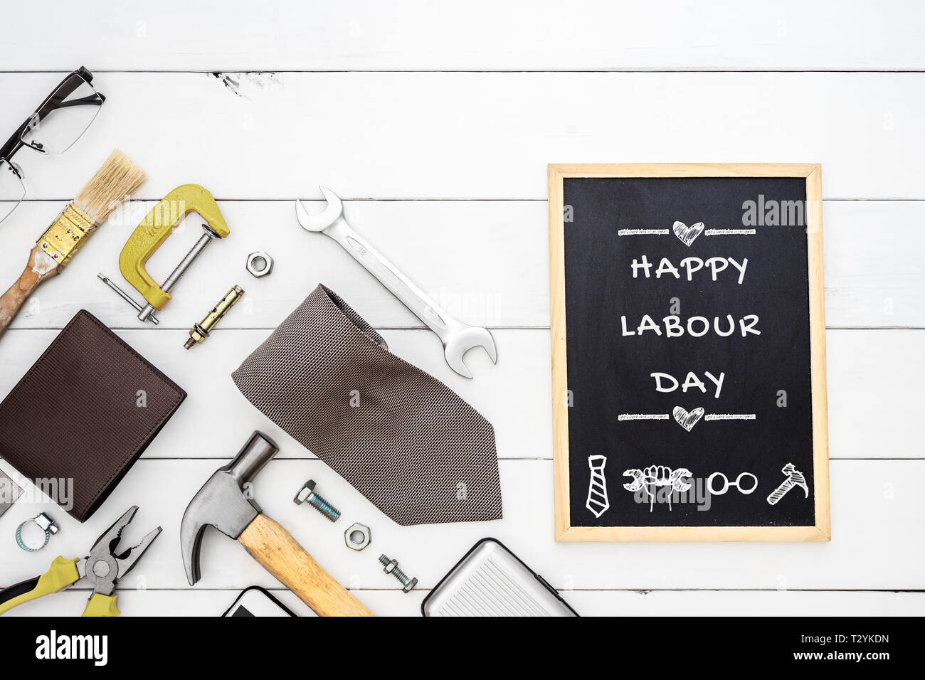 Happy Labour Day background concept. Flat lay of construction blue collar handy tools and white collar's accessories over wooden background with black Stock Photo