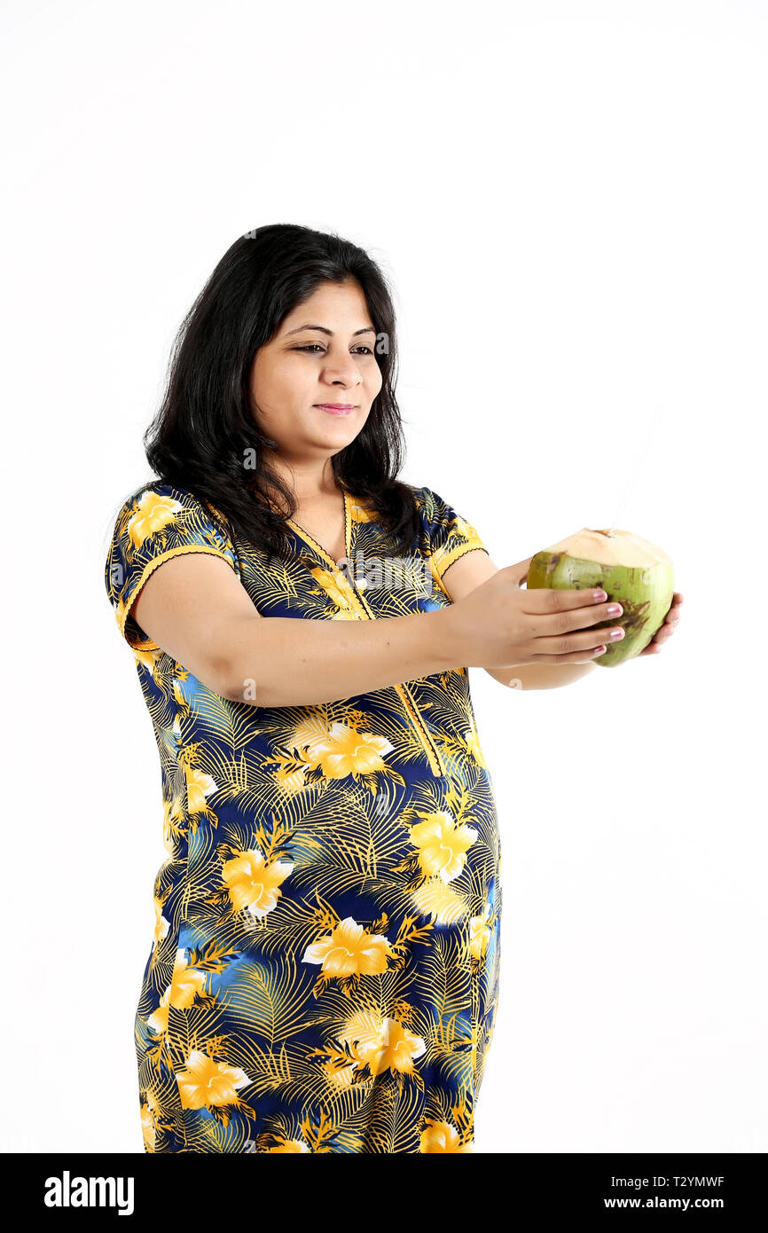 Young pregnant lady is holding coconut water with smile face. Isolated