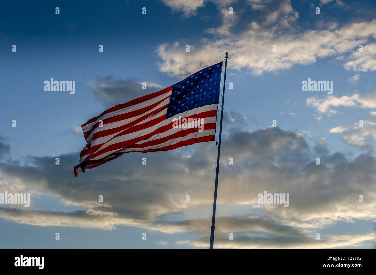 The Flag of the United States of America flying on a pole in a cloudy ...