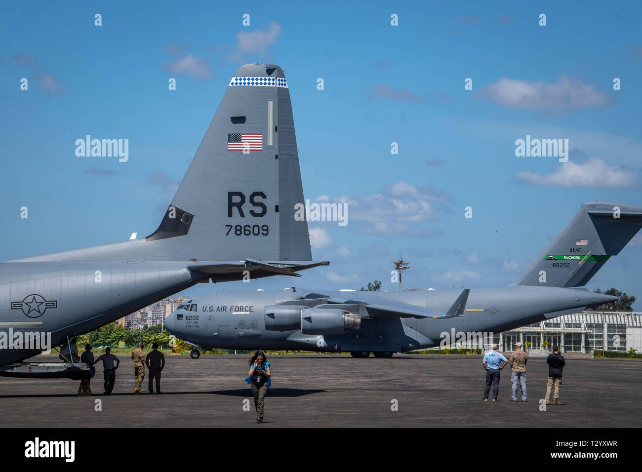 A U.S. Air Force C-17 assigned to the 16th Airlift Wing, Joint Base Charleston, Charleston, South Carolina, taxies into position as a U.S. Air Force C-130J Hercules assigned to the 75th Expeditionary Airlift Squadron, Combined Joint Task Force-Horn of Africa (CJTF-HOA) is loaded with aid from the United Nations International Children's Emergency Fund (UNICEF), at the airport in Maputo, Mozambique, April 4, 2019. The task force is helping meet requirements identified by USAID assessment teams and humanitarian organizations working in the region by providing logistics support and manpower to USA Stock Photo