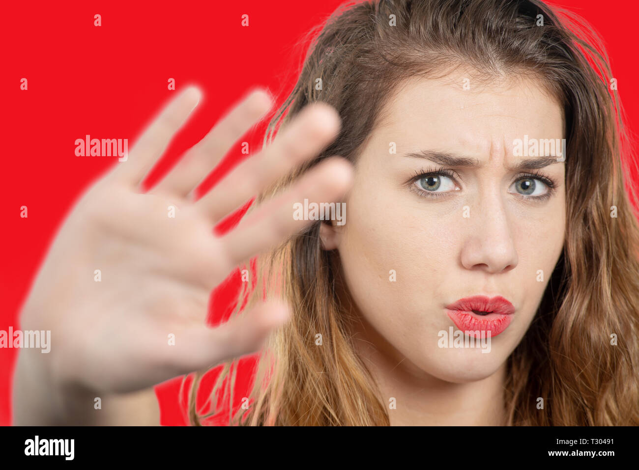 a portrait of a beautiful girl showing stop sign with palm Stock Photo