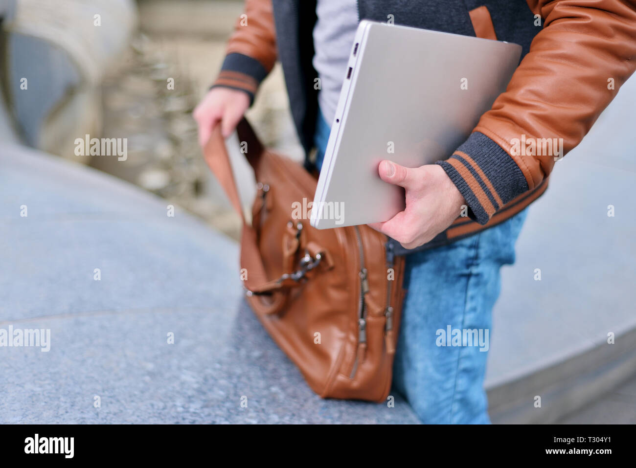 Hand putting laptop in bag hires stock photography and images Alamy