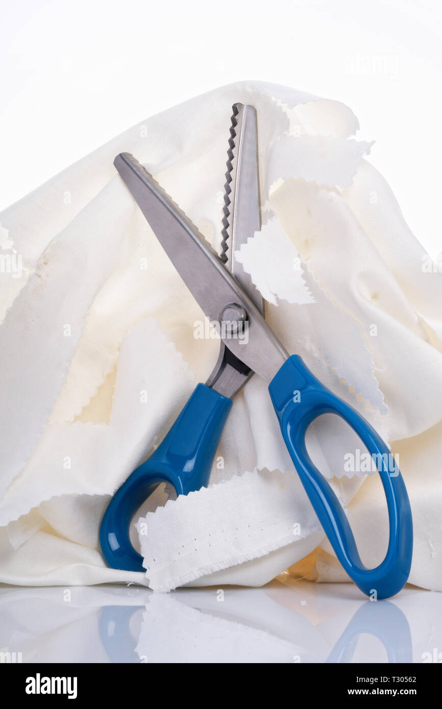 https://c8.alamy.com/comp/T30562/pinking-shears-cutting-a-white-cotton-material-T30562.jpg