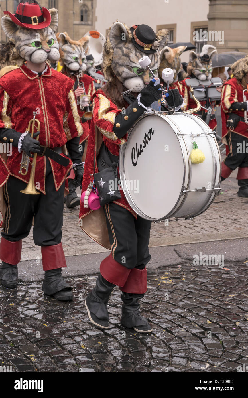 STUTTGART, GERMANY - MARCH 5: bass drummer player in a marching band with players dressed up as cats in parade under light rain.  Shot at  Carnival pa Stock Photo
