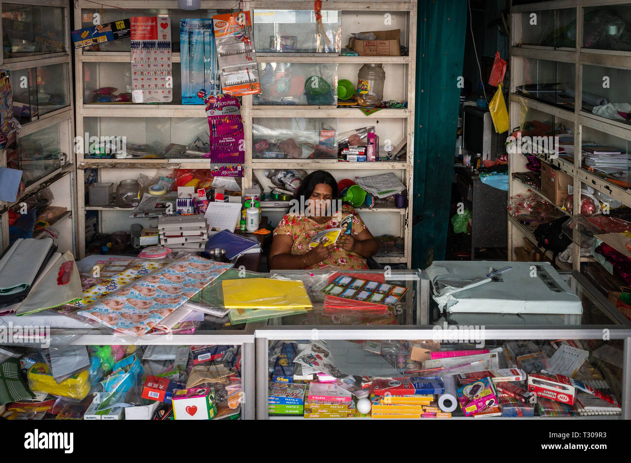 Woman reading alone at a stationery shop, Colombo, Sri Lanka Stock Photo -  Alamy
