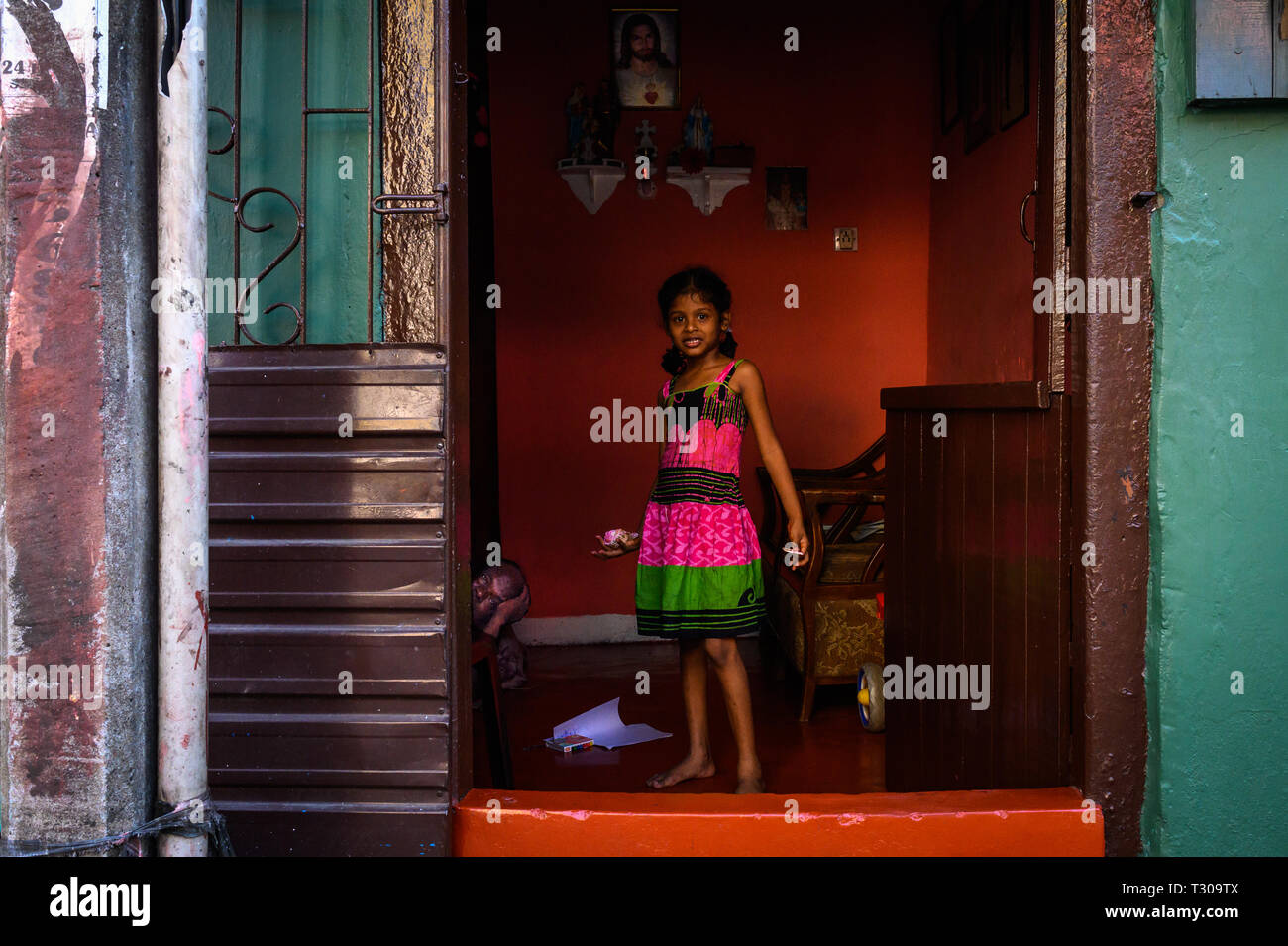 Girl standing in the doorway of her home, Colombo, Sri Lanka Stock Photo