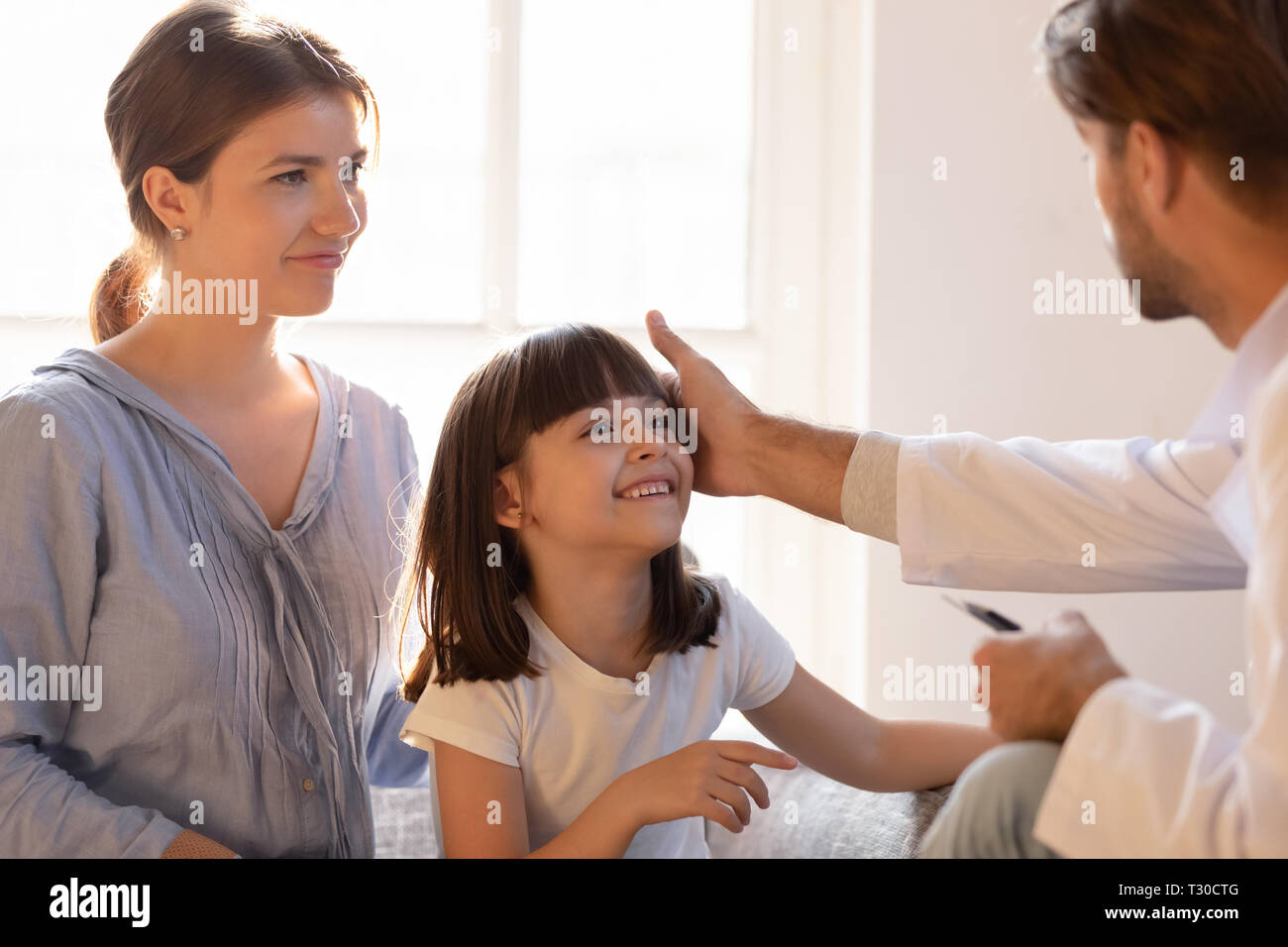 Paediatrician stroking patient girl encourages her before medical