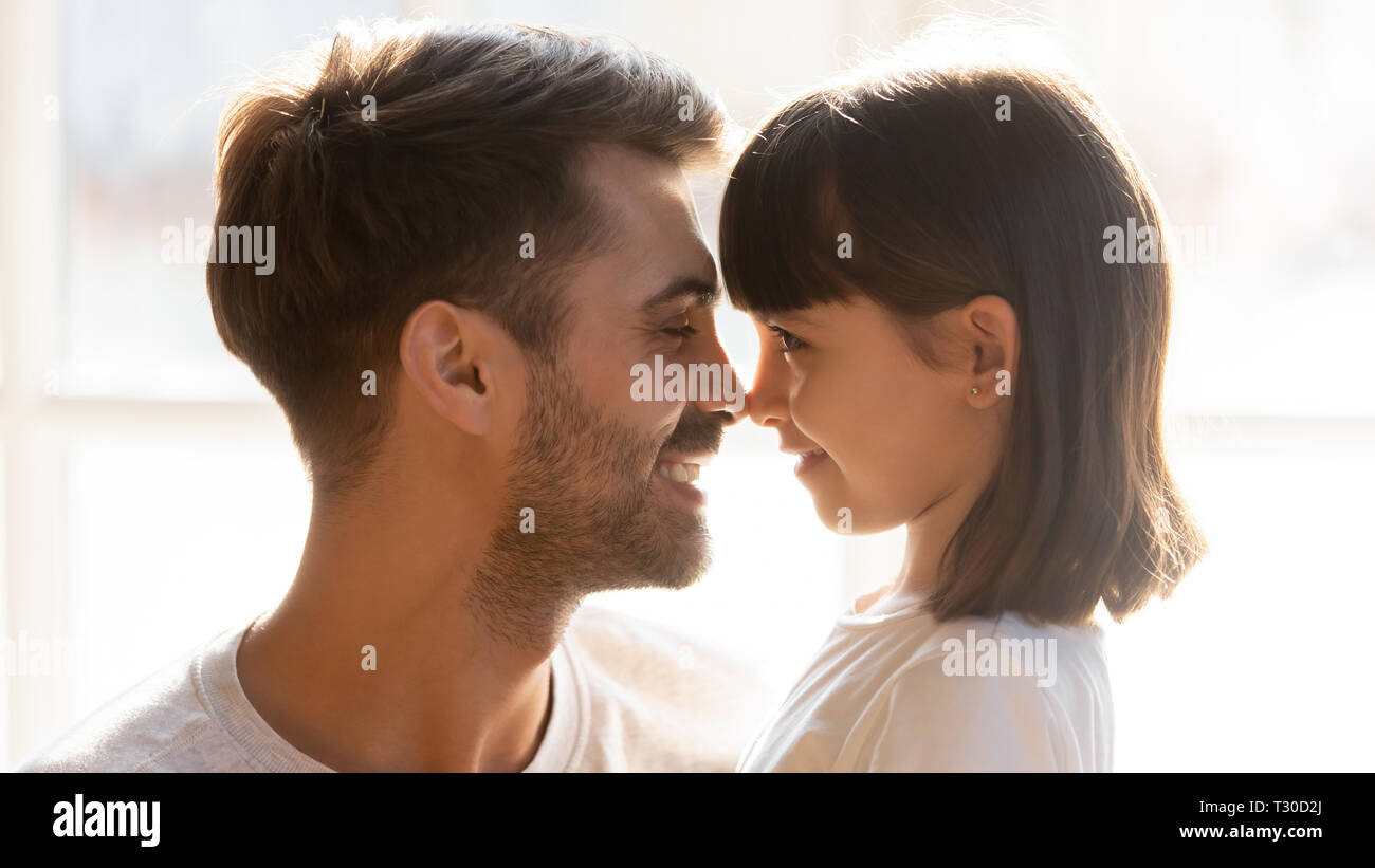 Faces loving father and adorable daughter touching noses Stock Photo