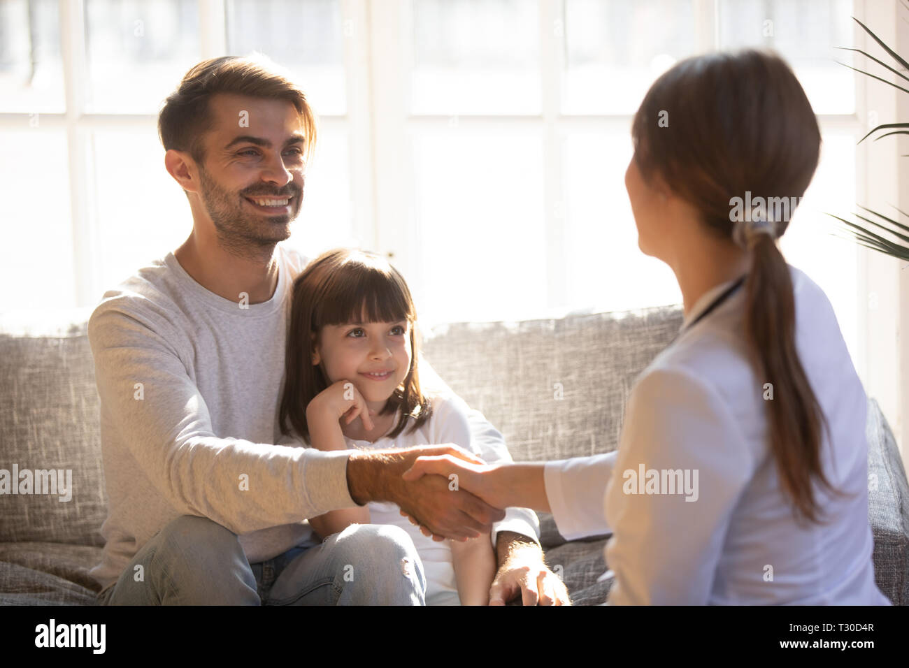 Daughter with father having visit paediatrics handshaking with paediatrician Stock Photo