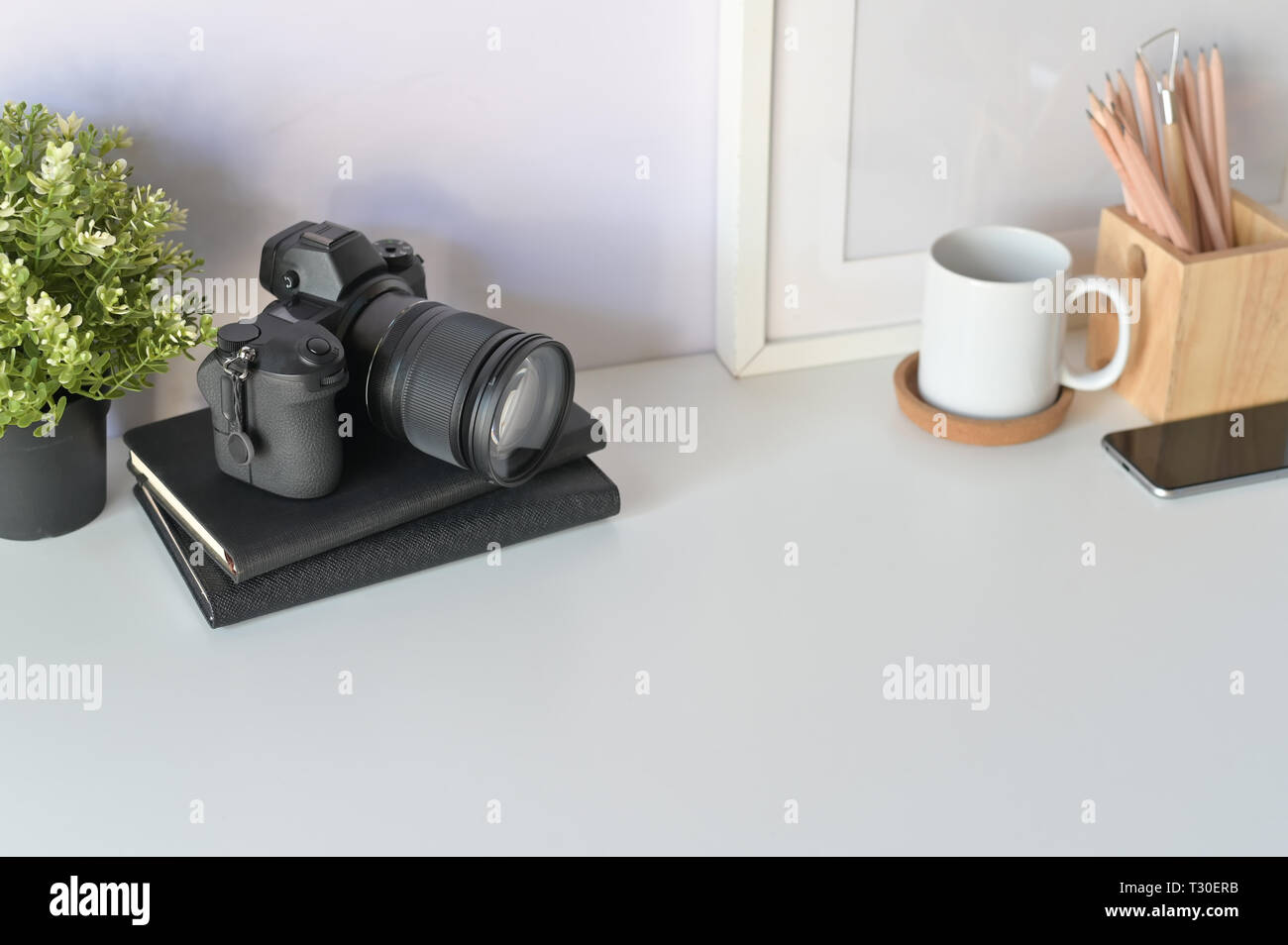 Photographer desk concept. designers table, photo camera, notebook