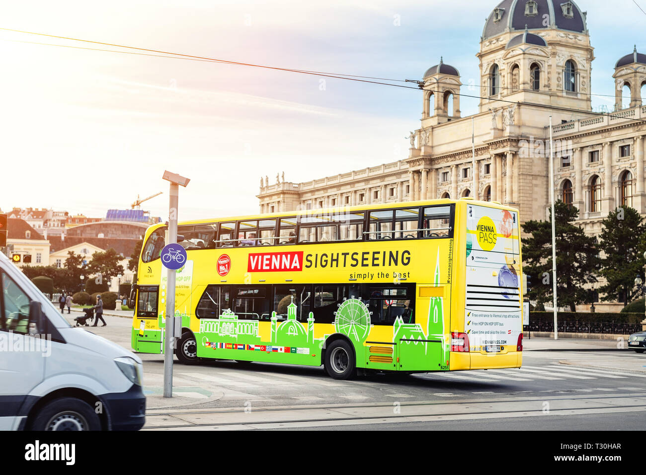 Vienna, Austria - January 16th,2019:Funny green-yellow doubledecker touristic sightseeing bus going along Vienna old city center on bright sunny day.A Stock Photo