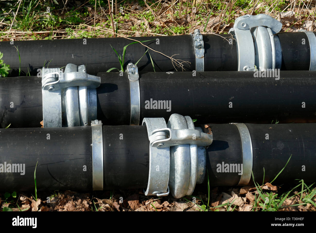 Black plastic pipes, white metal sleeves Stock Photo Alamy