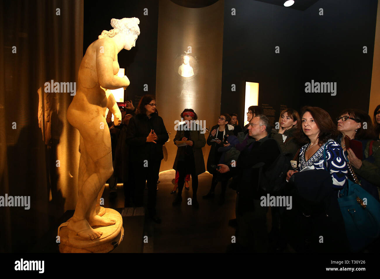 (190405) -- ATHENS, April 5, 2019 (Xinhua) -- Members of the Greek press look at a Roman statue of Greek goddess Aphrodite, which is displayed for the first time at the exhibition 'The Countless Aspects of Beauty' held by the National Archaeological Museum, in Athens, Greece, April 4, 2019. A marble statue of the Greek ancient goddess Aphrodite along with two scents from antiquity were unveiled at the National Archaeological Museum of Greece on Thursday to mark one-year anniversary of the temporary exhibition 'The countless aspects of Beauty.'   TO GO WITH 'Feature: Aphrodite statue on maiden  Stock Photo