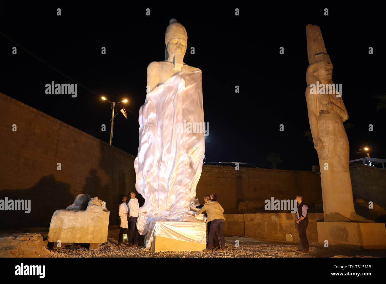 Sohag, Egypt. 5th Apr, 2019. People unveil a revived statue of Ramses II in Sohag, Egypt, April 5, 2019. Egyptian archeologists have pieced on Friday 70 fragments to revive a large statue of Ramses II in the upper Egypt's province of Sohag. Ramses II was the third pharaoh of the Nineteenth Dynasty of Egypt and was considered the strongest pharaoh of the New Kingdom that spans from the 16th century BC to the 11th century BC. Credit: Ahmed Gomaa/Xinhua/Alamy Live News Stock Photo