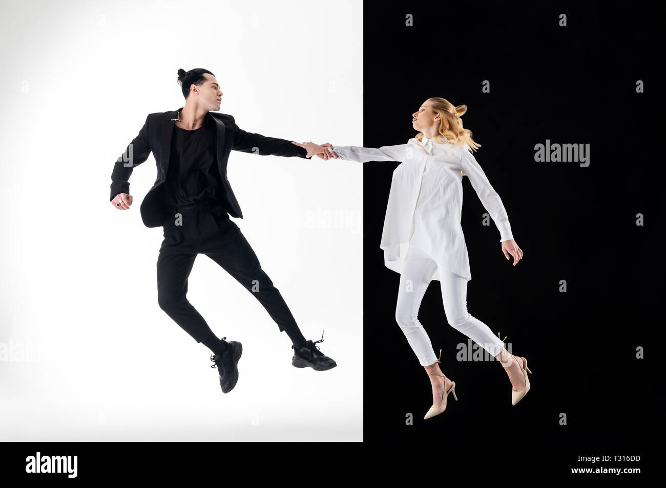Jumping for shot. Professional young models in black and white clothing jumping for nice shot Stock Photo