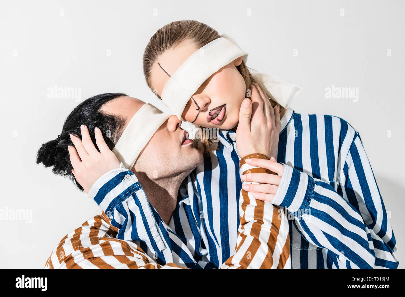 Male And Female Models Having Blindfolds And Lines On Face Stock