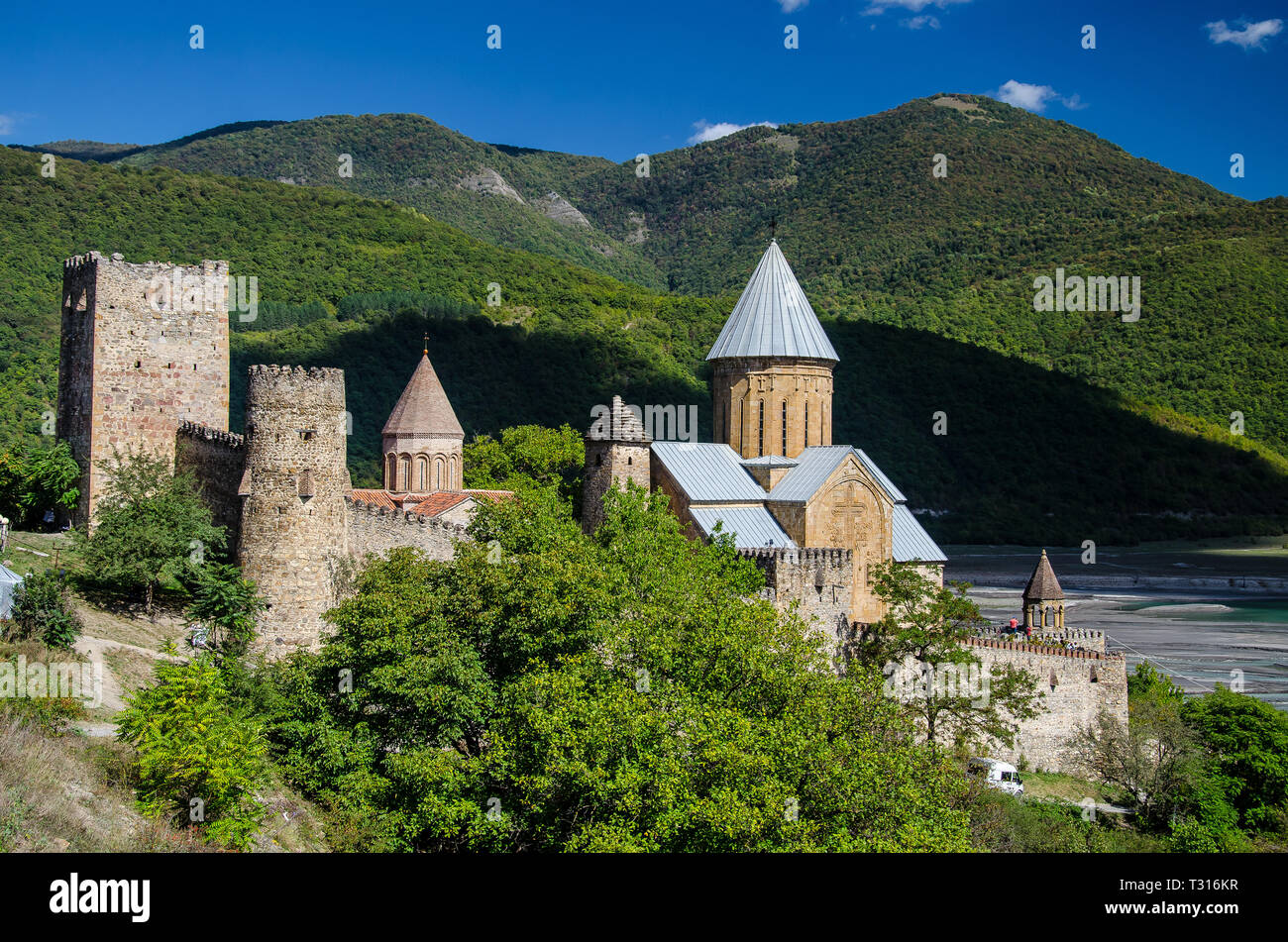 Church of the Mother of God, Ananuri with mountains in the background and blue sky with few clouds above Stock Photo