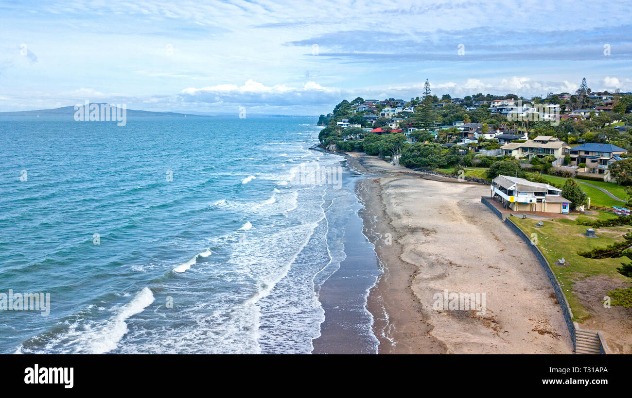 aerial view of mairangi beach, on a windy and wavy day in auckland, new