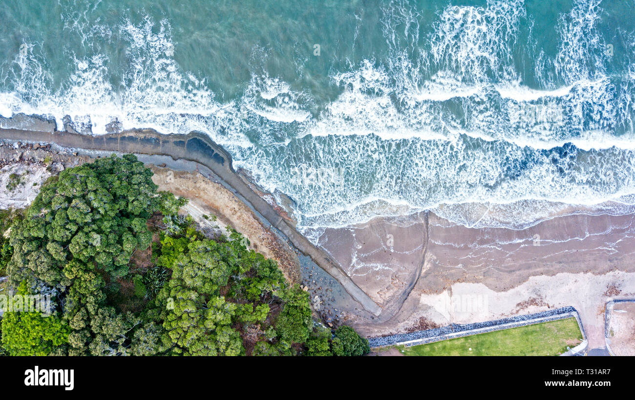 aerial view of mairangi beach, on a windy and wavy day in auckland, new