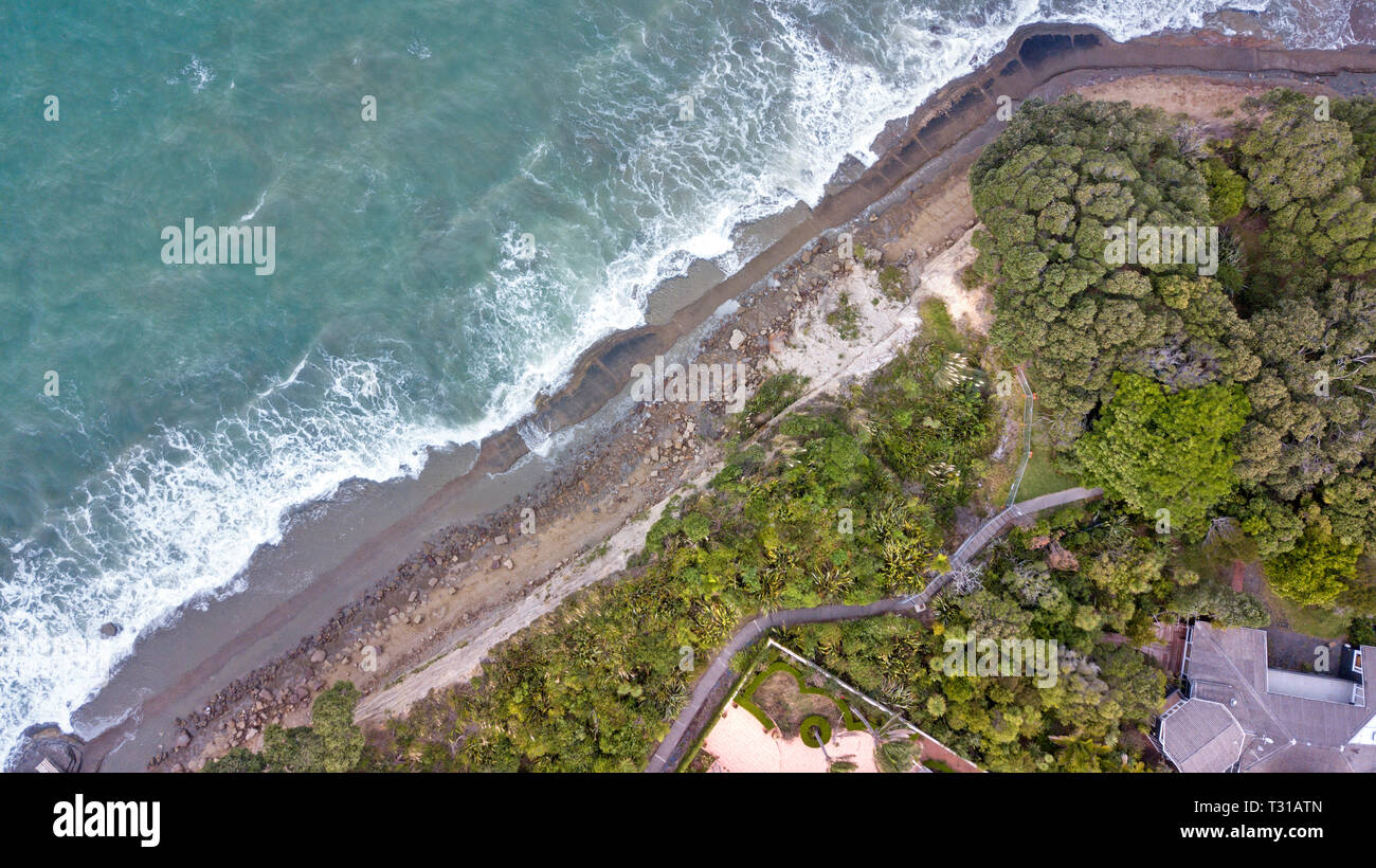 aerial view of mairangi beach, on a windy and wavy day in auckland, new