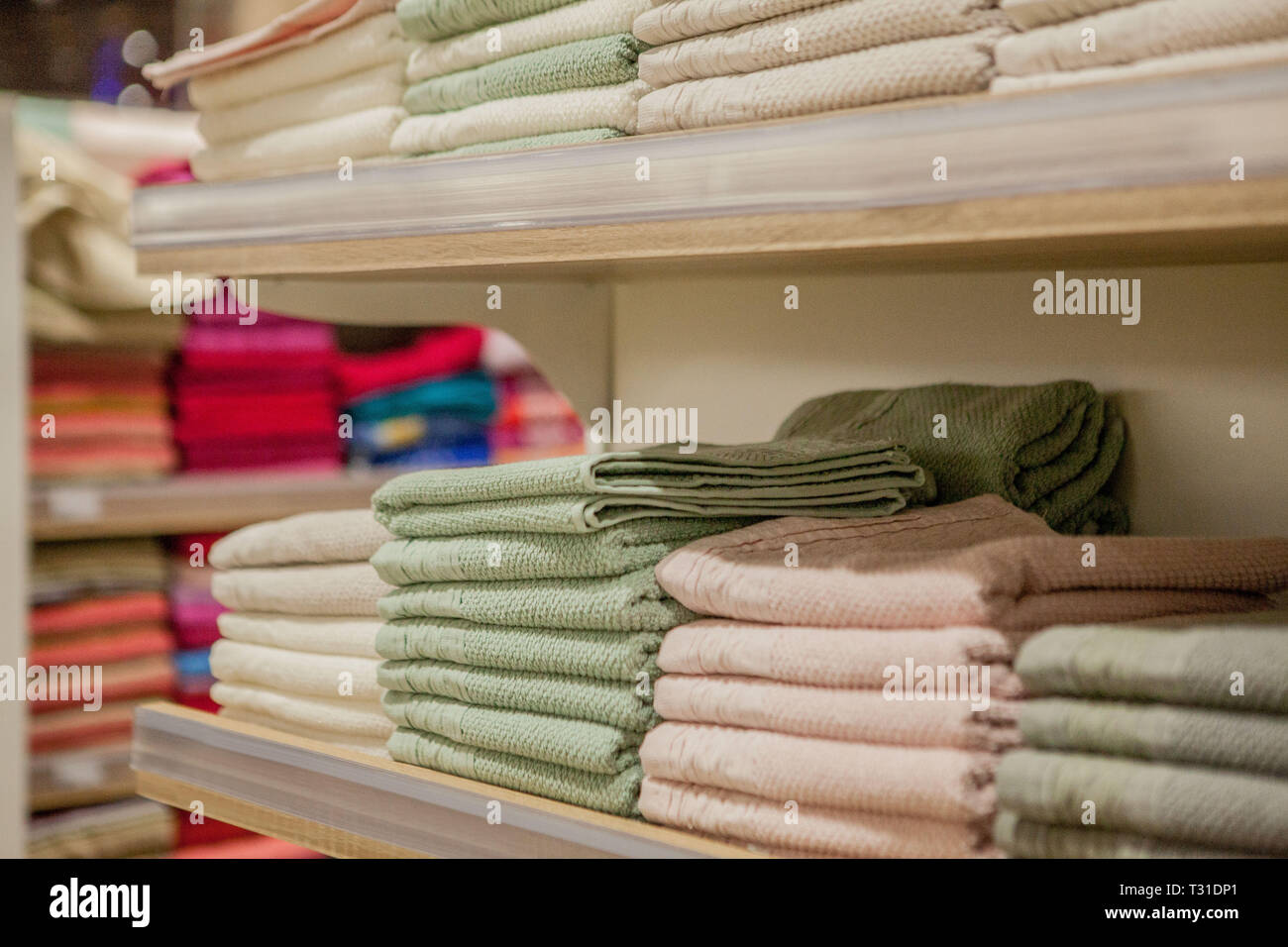 Stack of colorful towels in the department store. Many pile of cotton towels in store shop