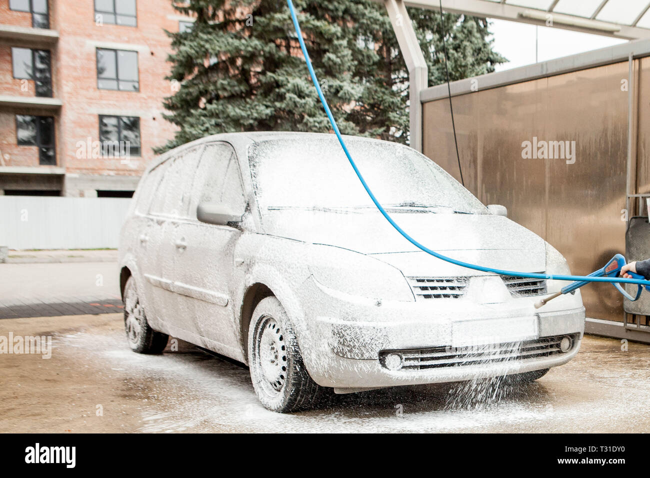 Car wash with foam in car wash station. Carwash. Washing machine at the station. Car washing