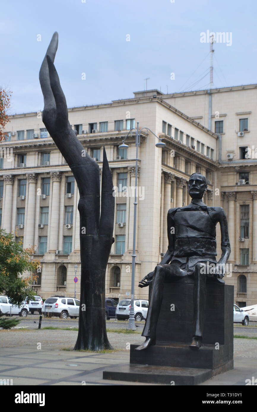 Bucharest: Romania 'Broken Man' & 'Hand' sculpture of Iuliu Maniu, The Memorial of Rebirth, Revolution Square, Central Committee building behind. Stock Photo