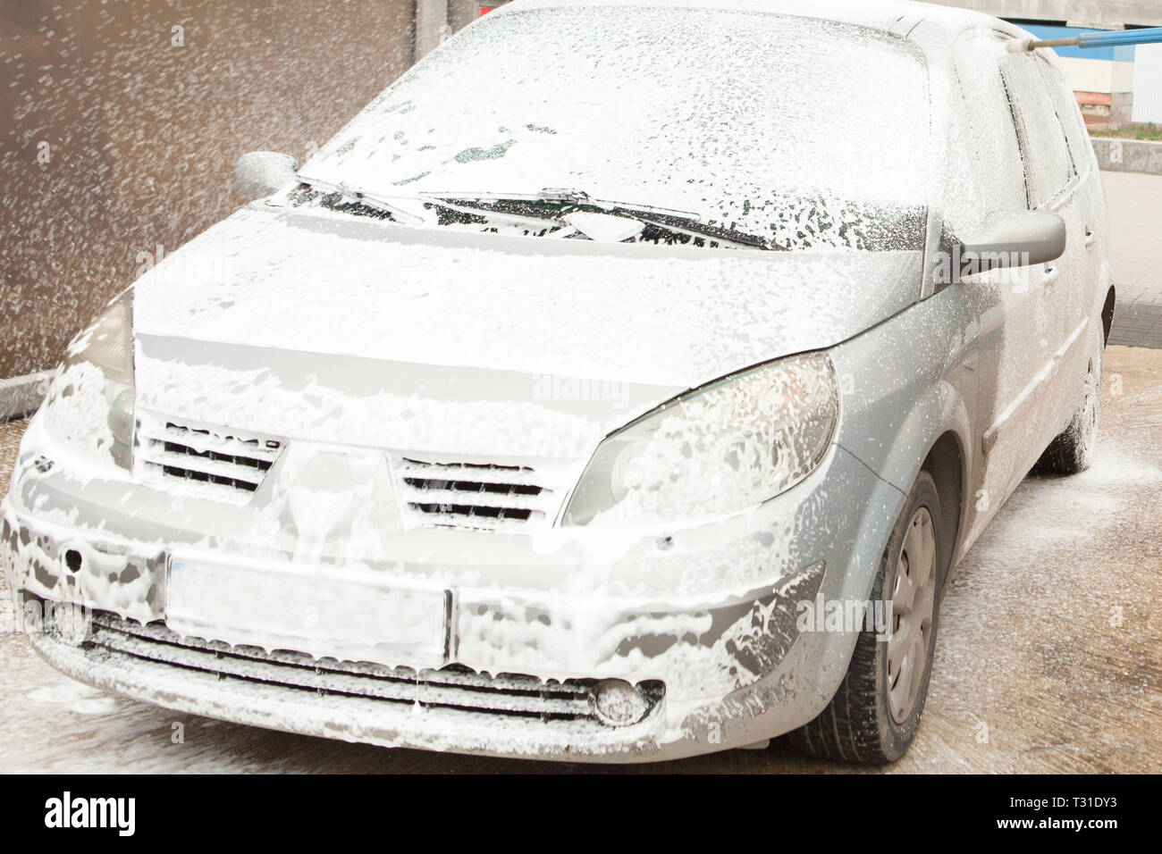 Car wash with foam in car wash station. Carwash. Washing machine at the  station. Car washing concept. Car in foam Stock Photo - Alamy