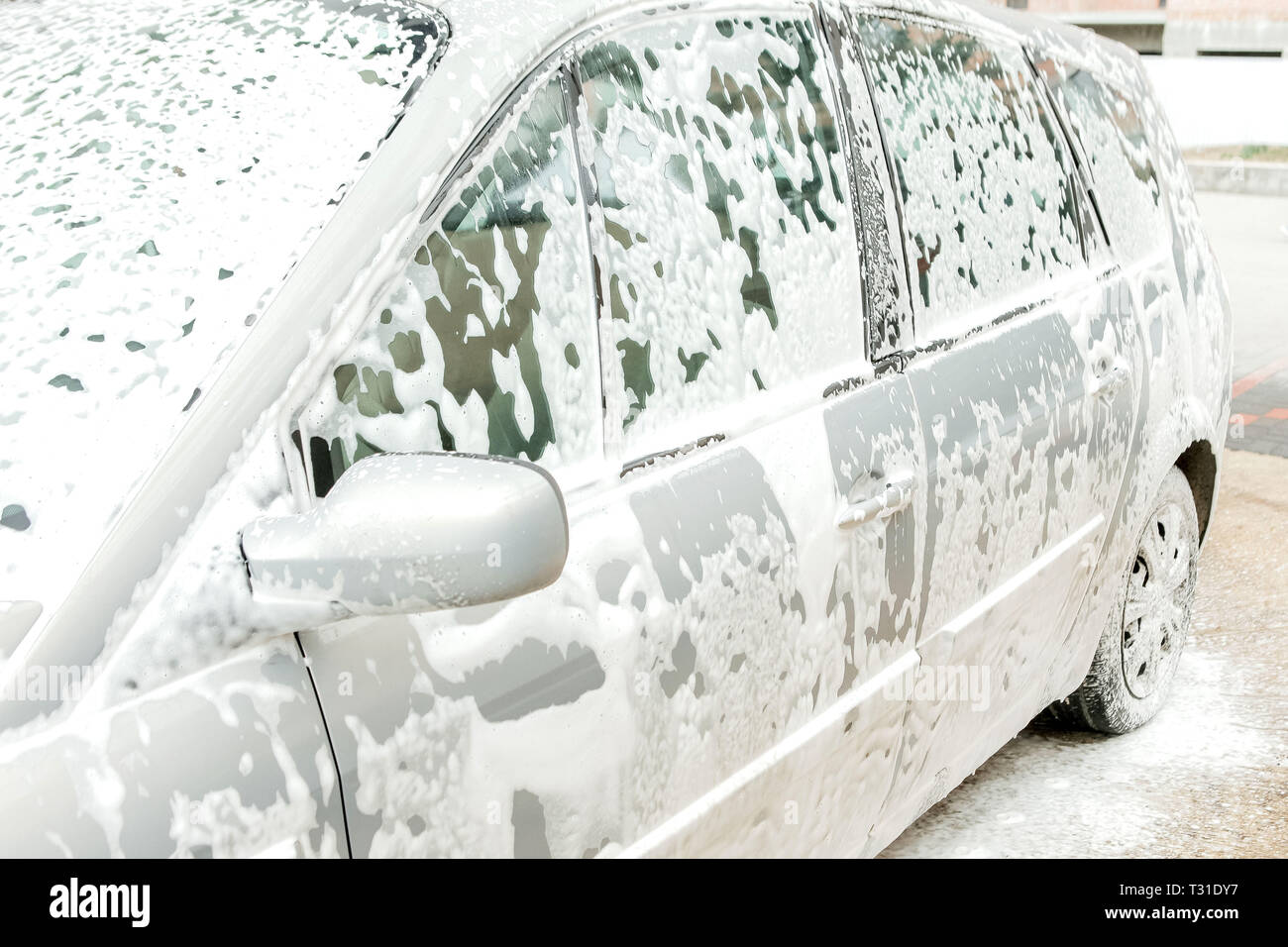 Car wash with foam in car wash station. Carwash. Washing machine at the