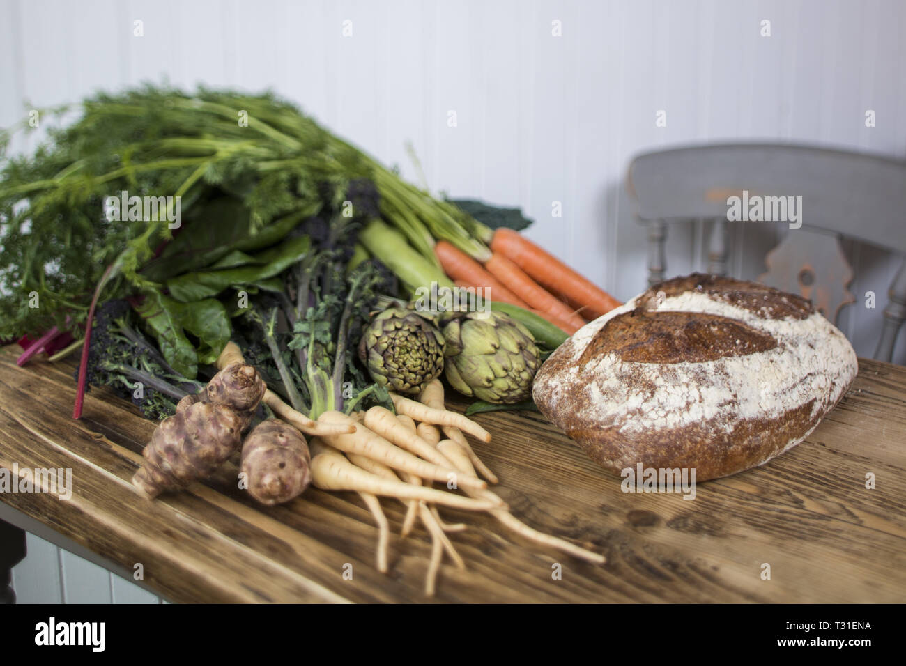 fresh produce on a wooden table with a loaf of sourdough bread Stock Photo