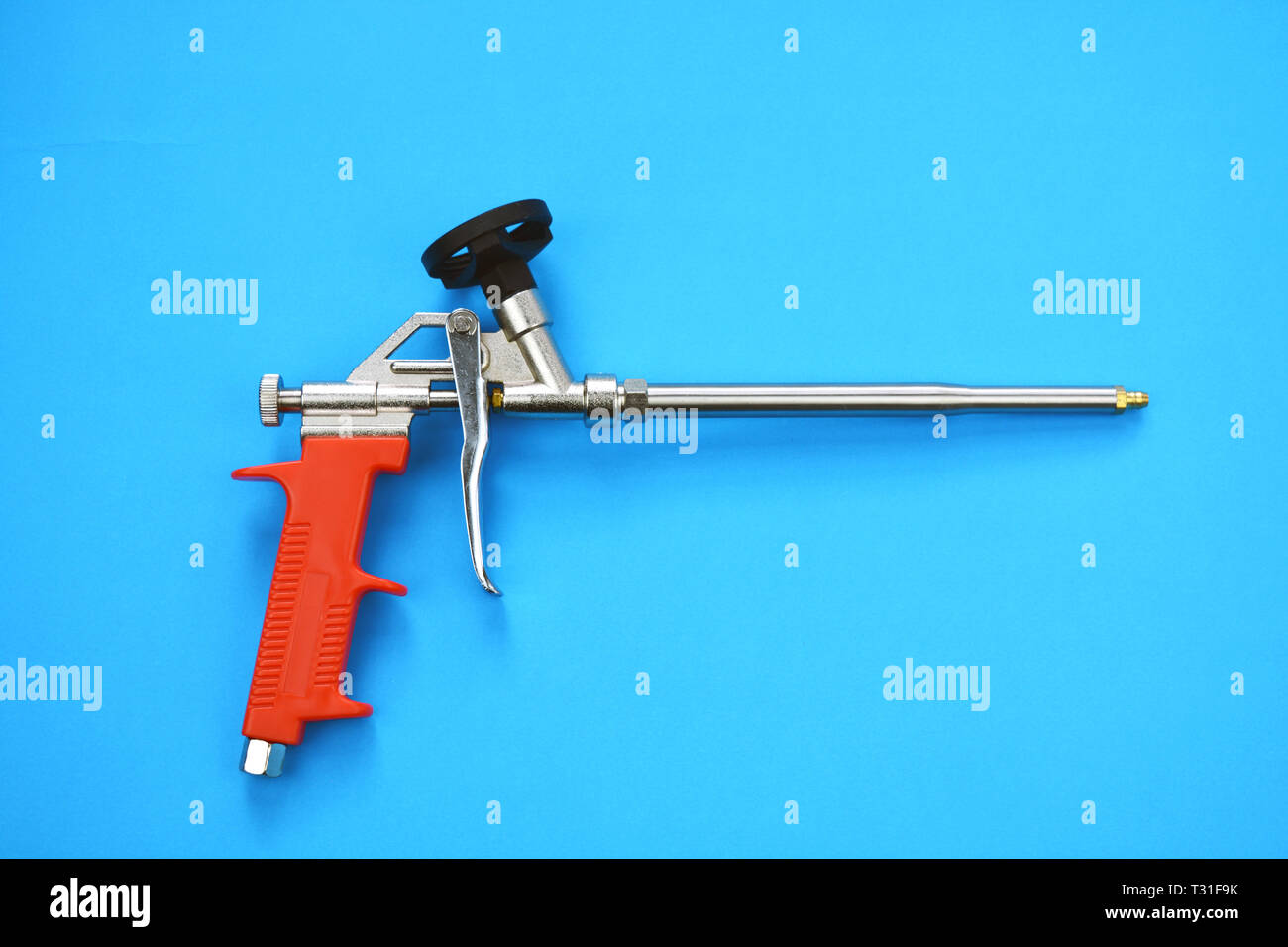 New mounting foam sprayer gun pistol tool on blue background Stock