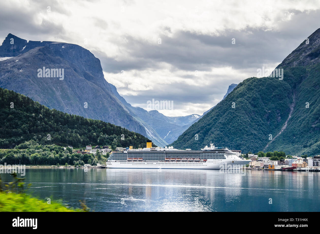 Sailing ship on a Norway fjord with mountains behind and clouds above. Stock Photo