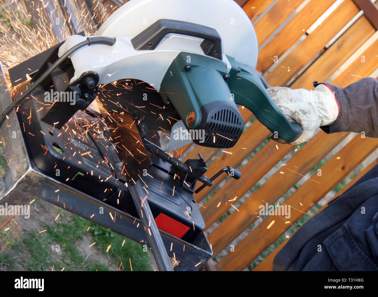 Worker grinding a metal part with standard protection equipment Stock