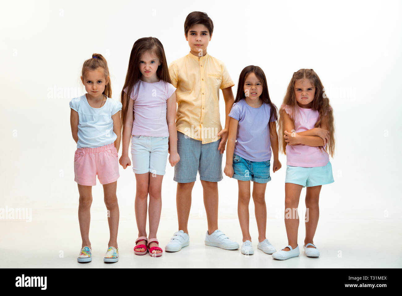 The portrait of happy cute little kids boy and girls in stylish casual  clothes looking at camera against white studio wall. Kids fashion and human  emotions concept Stock Photo - Alamy