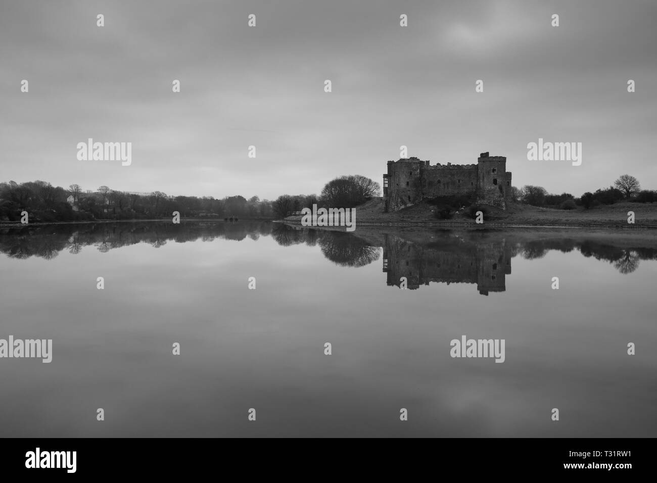 Carew Castle reflecting in the water on a misty morning, Pembrokeshire Stock Photo