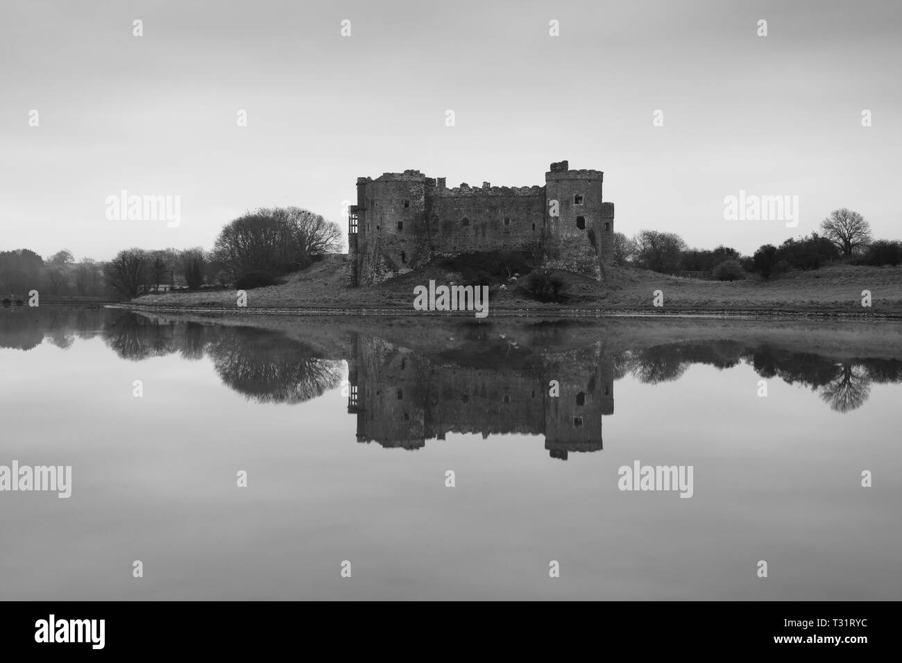 Carew Castle reflecting in the water on a misty morning, Pembrokeshire Stock Photo