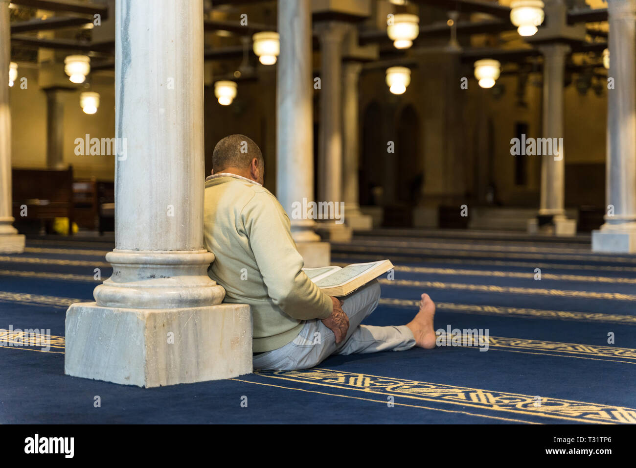 A man reciting the Quran in a mosque Stock Photo