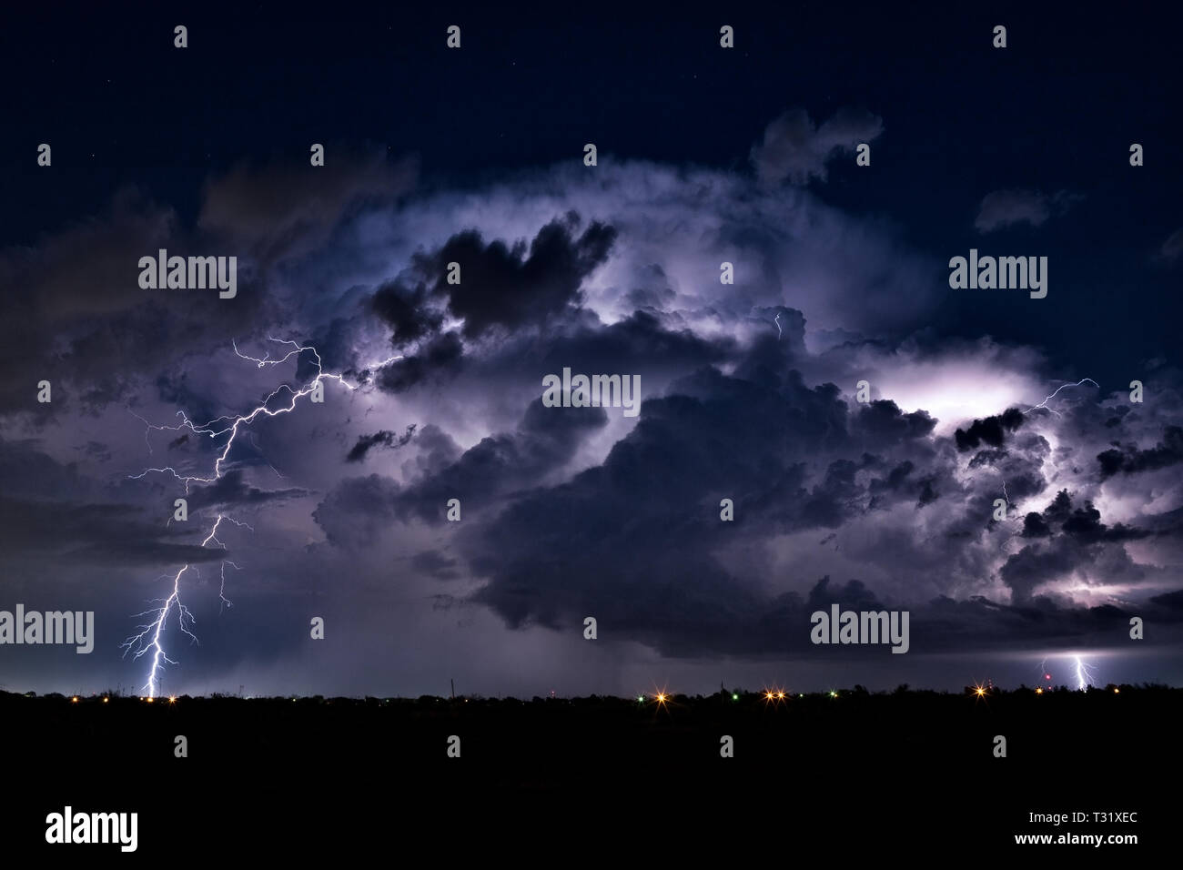 Lightning bolt in the night sky as a thunderstorm cumulonimbus cloud passes Midland, Texas Stock Photo
