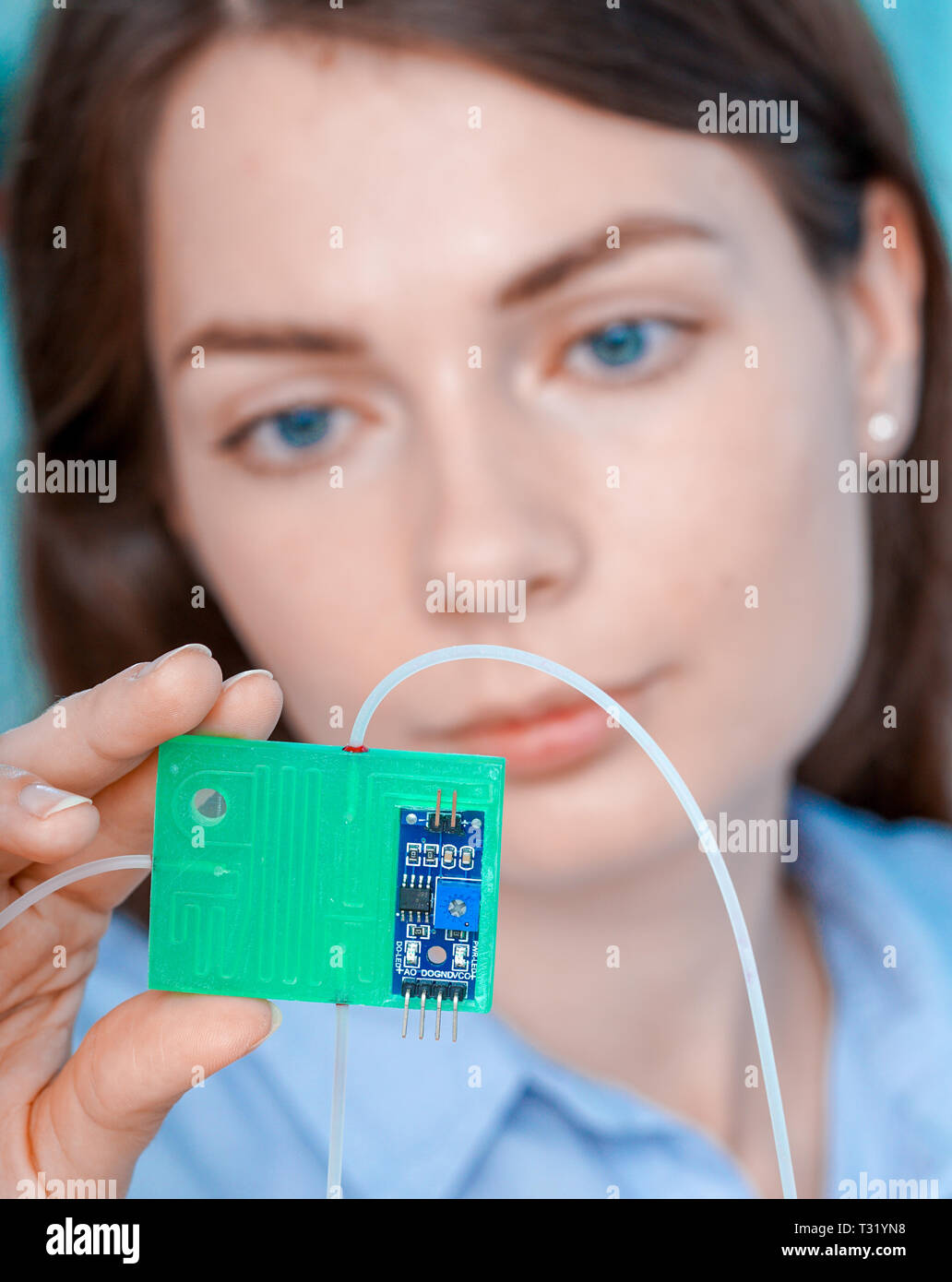 Girl holding polymers Bio-MEMS biomedical microelectromechanical systems / LOC lab-on-a-chip device (concept design) Stock Photo