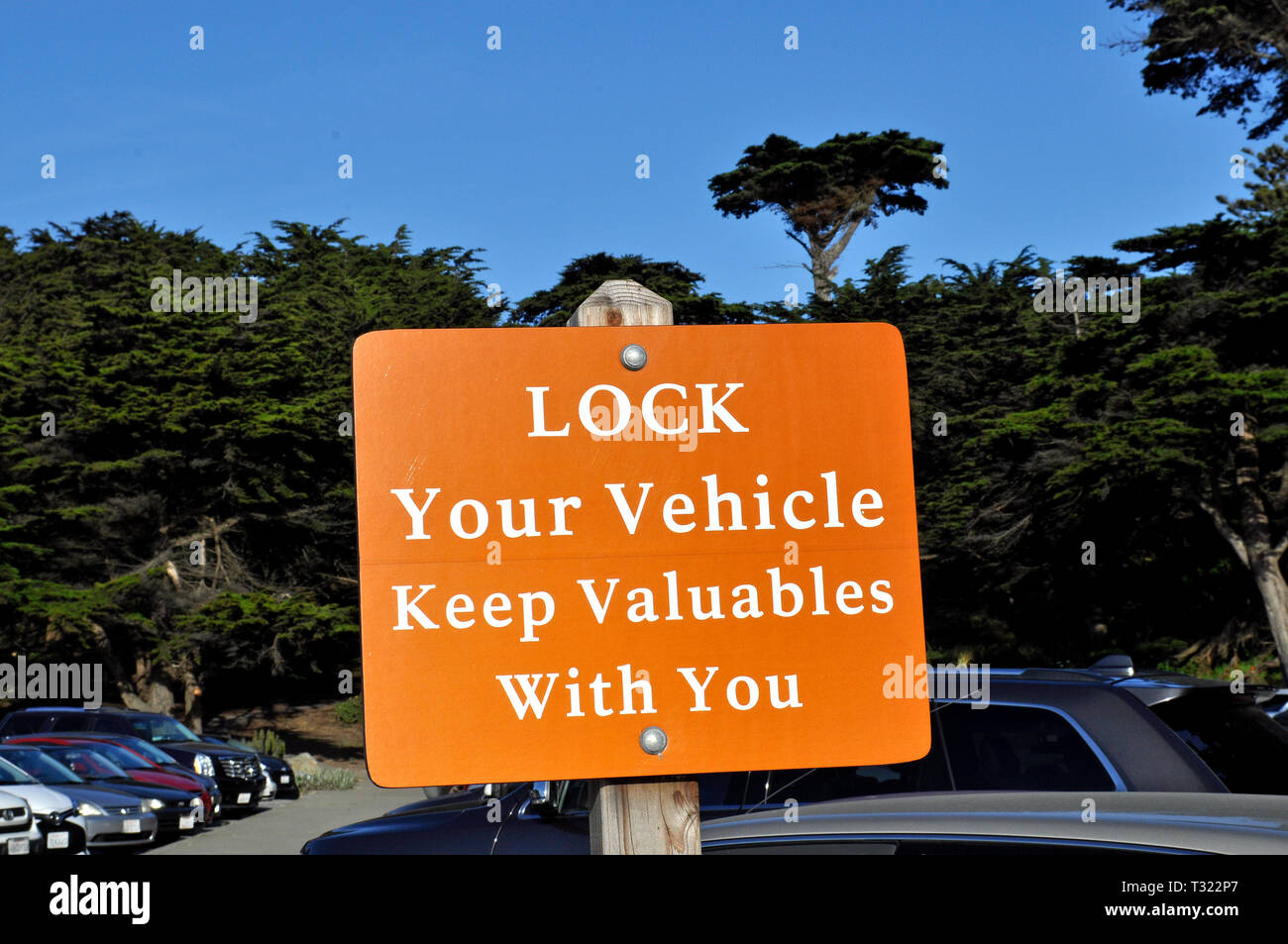 Lock your vehicles, keep your Valuables with you sign in a park's parking lot in San Francisco, California Stock Photo