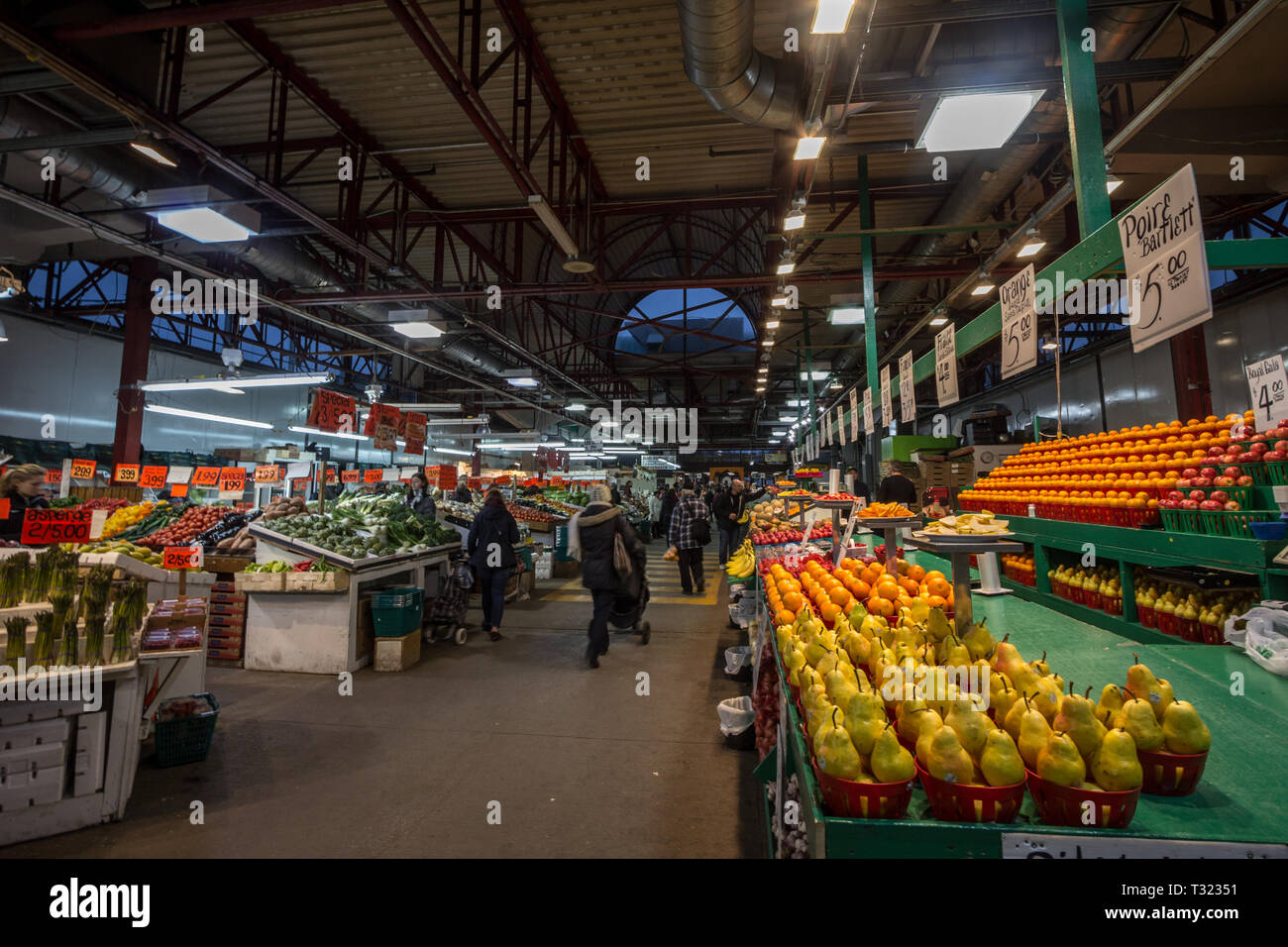 MONTREAL, CANADA - NOVEMBER 9, 2018: Main alley of Marche Jean Talon Market with merchants selling fruits, vegetables and groceries. It is a landmark  Stock Photo
