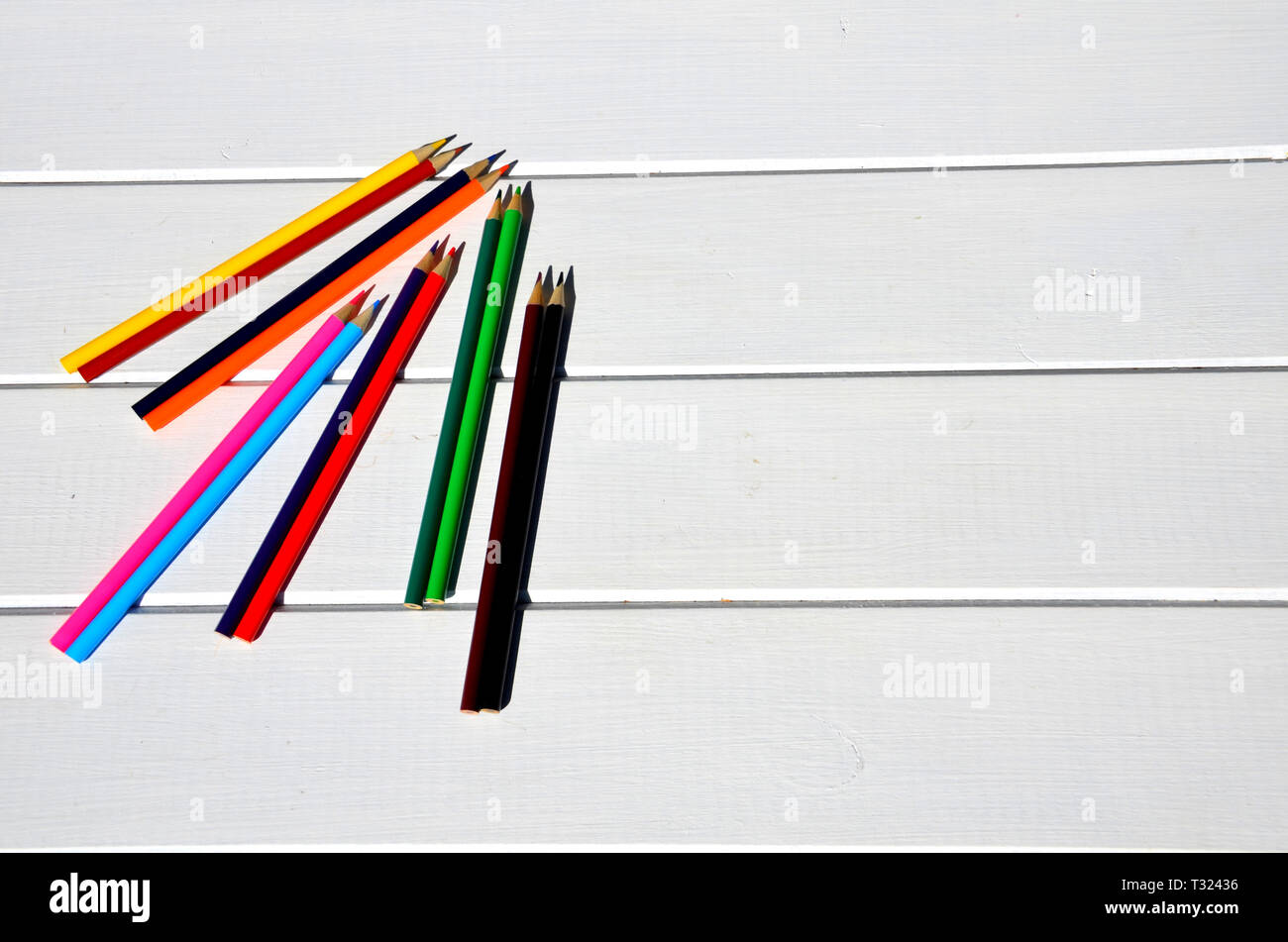 Colored pencils aligned on white pallet table Stock Photo